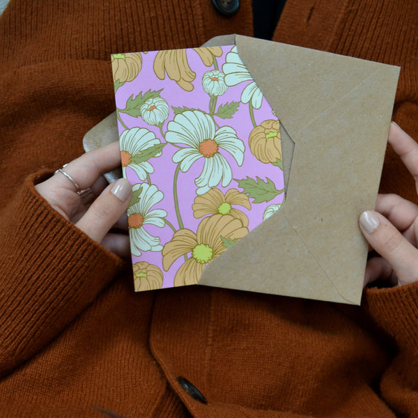 hands holding a floral daisy card